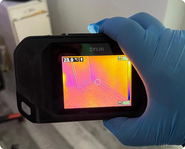Certified technician conducting a mold inspection with moisture-mapping equipment inside a home